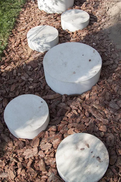 Caminho minimalista moderno de pedras redondas no Parque que conduz no chão casca ruminada de árvores — Fotografia de Stock