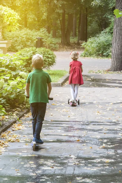 Mädchen mit Haarnadeln im roten Kleid und blonder Junge im grünen T-Shirt — Stockfoto