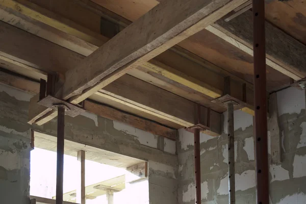 Ansicht der Holzschalung mit Metallhalterungen, die mit Überlappungen zwischen den Fußböden in einem im Bau befindlichen Landhaus aus Schaumstoffblock gefüllt wird — Stockfoto