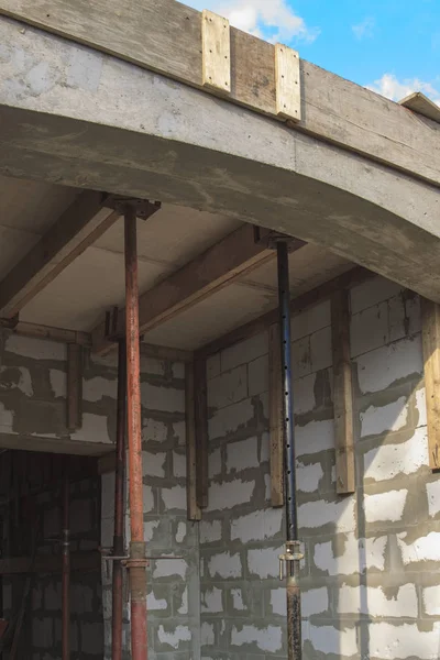 Blick auf die Holzschalung mit Metallhalterungen, die vom Schaumstoffblock aus mit der Überlappung zwischen den Fußböden des im Bau befindlichen Landhauses gefüllt wird — Stockfoto