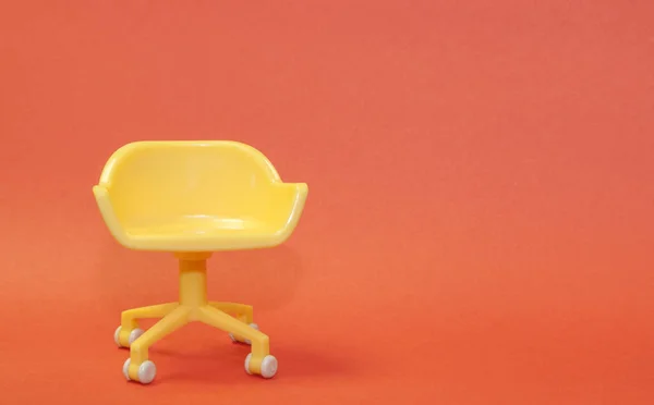Begreppet ledig stol. Gul pall på orange ren bakgrund. Foto i minimal stil. — Stockfoto