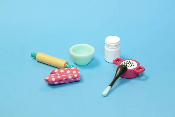 Platte lay afbeelding van plastic speelgoed servies met oven handschoen op pastelblauwe achtergrond — Stockfoto