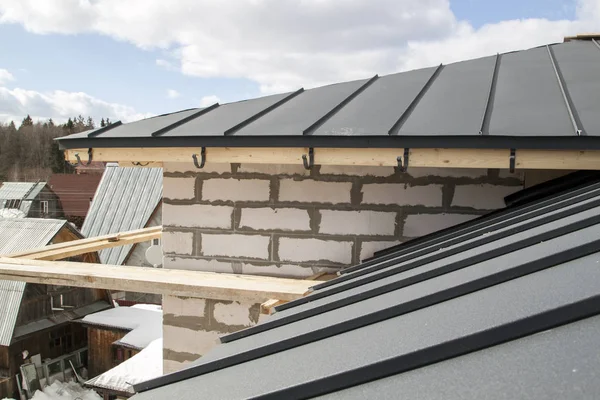 Close up άποψη της σκαλωσιές και το σπίτι υπό κατασκευή με γκρι πτυσσόμενη οροφή για στεγάνωση στρώμα — Φωτογραφία Αρχείου