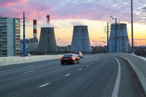 Strada con vetture che passano in successione con centrale termica a su — Foto Stock