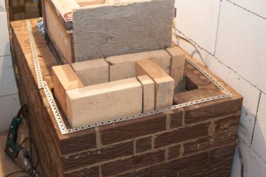 Kır evindeki köpük bloklardan inşa edilen ateşe dayanıklı malzemeden inşa edilen sauna sobası.