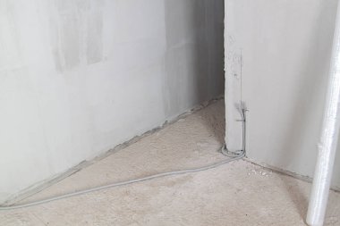 Elektrik kablosu, duvardaki oyukta koruma kablosuna yerleştirilir. Elektrik kabloları prizleri ve anahtarları birbirine bağlamak için duvarda taşınır.