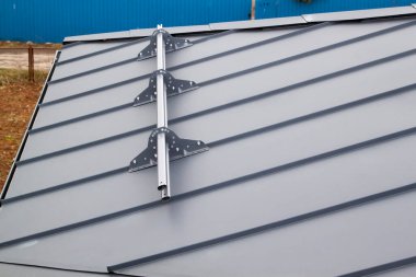 Vidaları gri çatıya bağlı metal kar koruyucunun görüntüsü