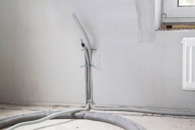 Elektrik kablosu, duvardaki oyukta koruma kablosuna yerleştirilir. Elektrik kabloları prizleri ve anahtarları birbirine bağlamak için duvarda taşınır.