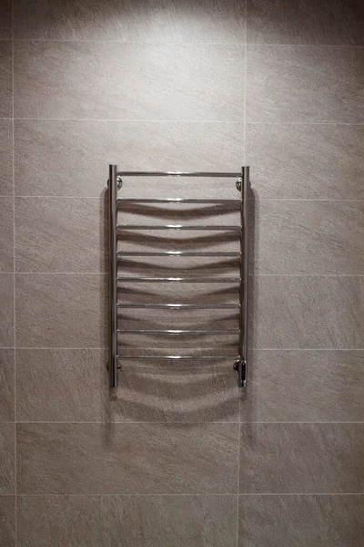 electric heated towel rail with hidden connection hanging on the wall with ceramic tiles