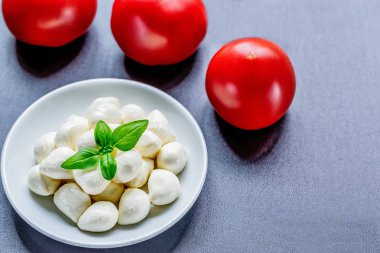 Olgun kırmızı domates ve fesleğen yaprakları ile lezzetli Mozzarella peynir topları