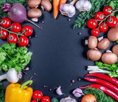 Farklı çiğ sebze ve siyah arka plan üzerine baharat. 