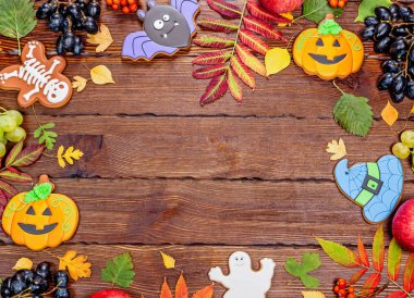 Ahşap masa üzerinde Cadılar Bayramı gingerbreads, sonbahar yaprakları ve meyveleri üstten görünüm