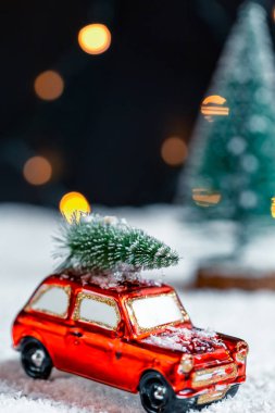 Noel arka plan yeni yıl için hazırlanıyor. Noel ağacı karda bulanık bokeh arka plan çelenk üzerinde seyahat bir araç çatı üzerinde
