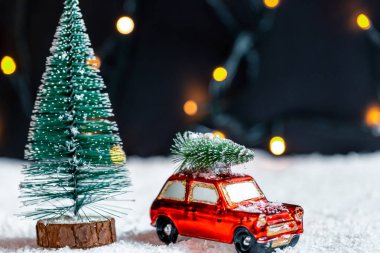 Noel arka plan yeni yıl için hazırlanıyor. Noel ağacı karda bulanık bokeh arka plan çelenk üzerinde seyahat bir araç çatı üzerinde