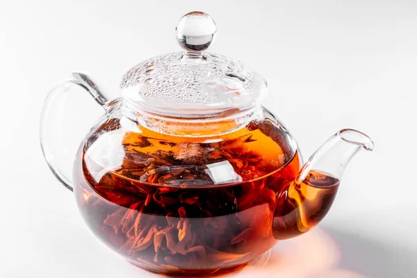 茶在一个玻璃茶壶与盛开的大花 茶壶与异国情调的绿茶在白色背景 — 图库照片