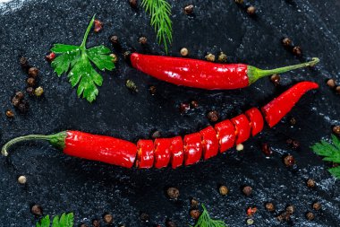 Taze biber baharat ve otlar siyah taş zemin üzerine ile baharatlı. Yemek yemek, yemek malzemeler kavramı. Üstten Görünüm. Flatley