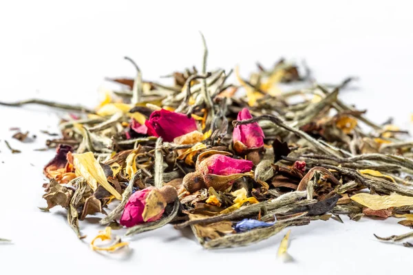 Witte thee met bloemen, bloemblaadjes en rosebuds op witte achtergrond. Close up van chinese witte thee van premium luxe kwaliteit. Textuur achtergrond macro foto. Bai Hao Yinzhen thee. — Stockfoto