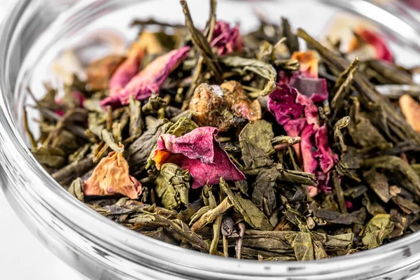 Kurutulmuş çiçek yaprakları ve beyaz arka plan üzerinde narenciye parçaları ile yeşil çay. Kaynak için Kuru çay. Diyet ve sağlıklı içecek — Stok fotoğraf