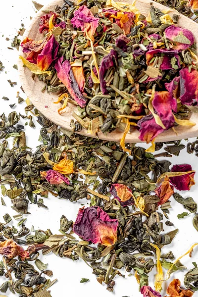 Kurutulmuş çiçek yaprakları ve bir tahta kaşık üzerinde narenciye parçaları ile yeşil çay. Kaynak için Kuru çay. Diyet ve sağlıklı içecek — Stok fotoğraf