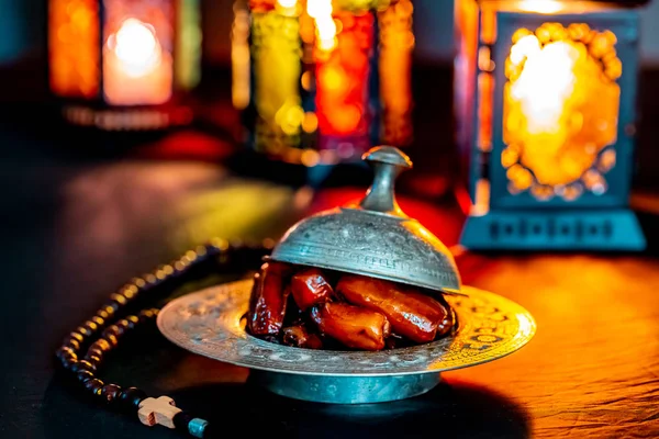 神圣的斋月卡雷姆的穆斯林盛宴 在黑暗的背景的托盘上的日期 美丽的背景与闪亮的灯笼法努斯 — 图库照片