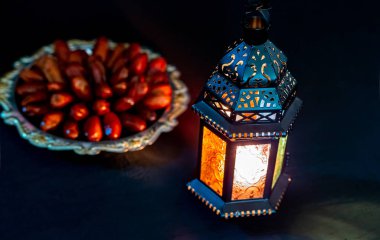 Karanlık bir arka plan üzerinde bir tepsi üzerinde tarihleri ile Ramazan Kareem kutsal ayın Müslüman bayram. Parlayan bir fener Fanus ile güzel bir arka plan. Metniniz için boş alan.