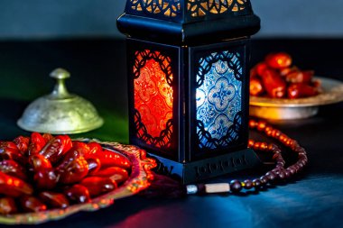 Karanlık bir arka plan üzerinde bir tepsi üzerinde tarihleri ile Ramazan Kareem kutsal ayın Müslüman bayram. Parlayan bir fener Fanus ile güzel arka plan.