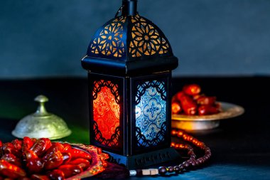 Karanlık bir arka plan üzerinde bir tepsi üzerinde tarihleri ile Ramazan Kareem kutsal ayın Müslüman bayram. Parlayan bir fener Fanus ile güzel arka plan.