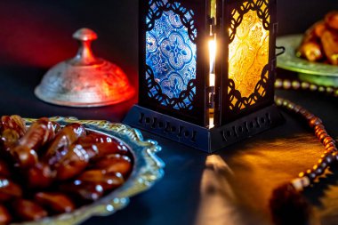 Karanlık bir arka plan üzerinde bir tepsi üzerinde tarihleri ile Ramazan Kareem kutsal ayın Müslüman bayram. Parlayan bir fener Fanus ile güzel arka plan.