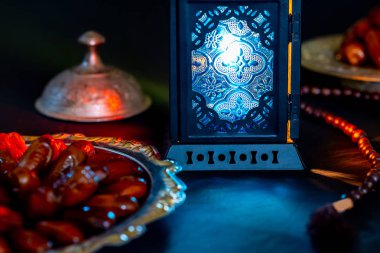 Karanlık bir arka plan üzerinde bir tepsi üzerinde tarihleri ile Ramazan Kareem kutsal ayın Müslüman bayram. Parlayan bir fener Fanus ile güzel arka plan.