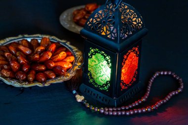 Karanlık bir arka plan üzerinde bir tepsi üzerinde tarihleri ile Ramazan Kareem kutsal ayın Müslüman bayram. Parlayan bir fener Fanus ile güzel arka plan.