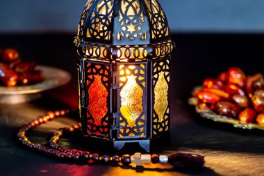 Karanlık bir arka plan üzerinde bir tepsi üzerinde tarihleri ile Ramazan Kareem kutsal ayın Müslüman bayram. Parlayan bir fener Fanus ile güzel arka plan.