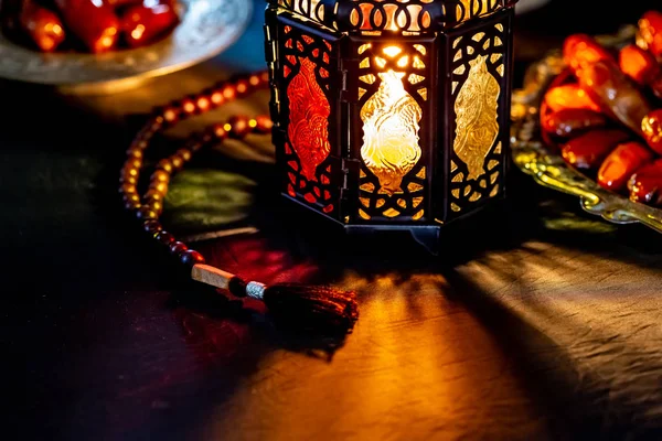 神圣的斋月卡雷姆的穆斯林盛宴 在黑暗的背景的托盘上的日期 美丽的背景与闪亮的灯笼法努斯 — 图库照片