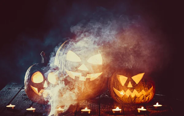 Halloween sütőtök fej jack lantern a gyertyák körül a régi deszkák a kísérteties éjszaka táj. Lágy fókusz. sekély Dof — Stock Fotó