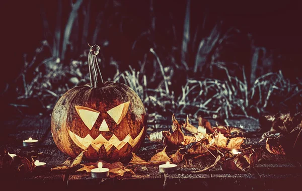 Halloween zucche testa jack lanterna con candele intorno sulle vecchie tavole in un paesaggio notte spettrale. Concentrati. DOF poco profondo — Foto Stock