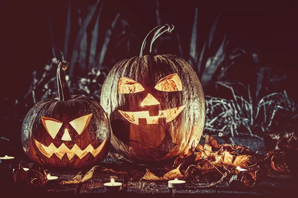 Halloween citrouilles tête Jack lanterne avec des bougies autour sur les vieilles planches dans un paysage nocturne effrayant. Concentrez-vous. DOF peu profond — Photo