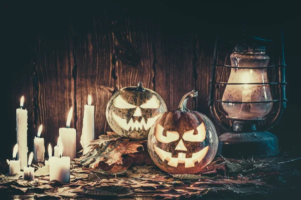 Halloween pumpkin with glowing face on a wooden background with