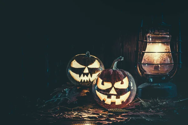 Halloween pumpkin with glowing face on a wooden background with