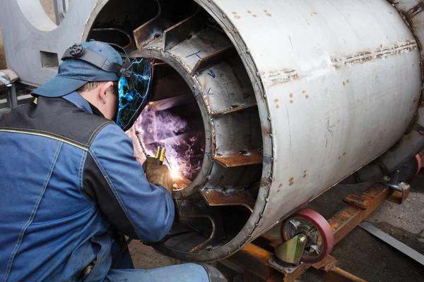 Fabrikada çalışan kaynakçılar metal üretiyorlar.