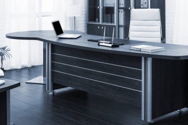 Modern ofisteki bir masada dizüstü bilgisayar