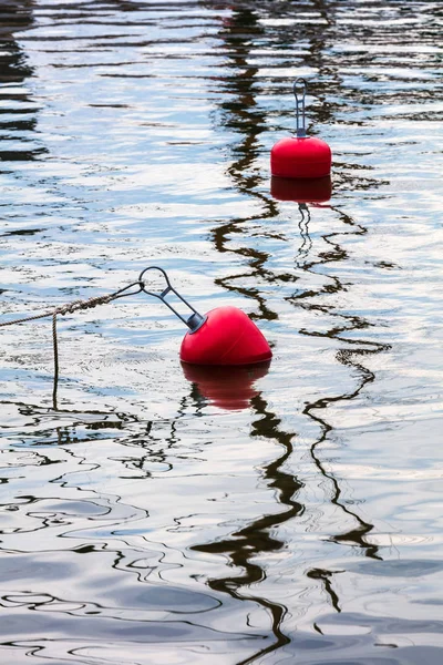 Boyas rojas flotando sobre el agua con reflejo —  Fotos de Stock