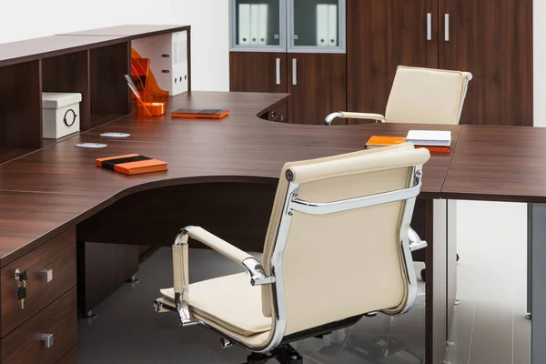 Table, leather armchair and bookcase on white wall — Stock Photo, Image