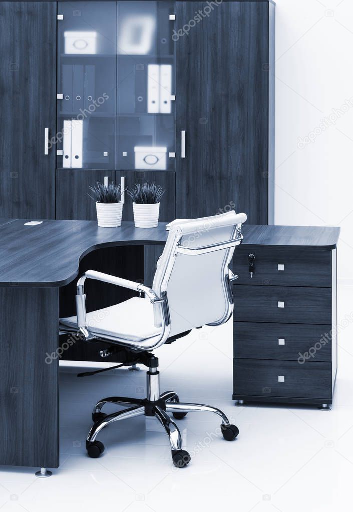 desk, chair and bookcase on white wall