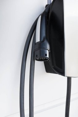 beyaz duvarda bir elektrikli araba şarj istasyonu