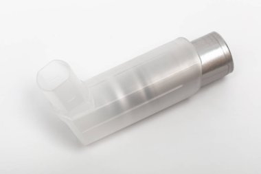 Beyaz zemin üzerinde uyuşturucu bulunan bir astım spreyi.