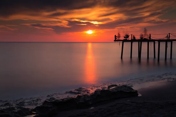 Silhouettes of fishermen on the pier — Stock Photo, Image