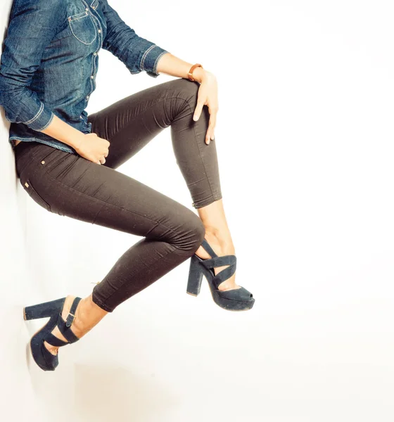 Chica en tacones altos negros y jeans grises. Medio cuerpo inferior sobre fondo gris . — Foto de Stock