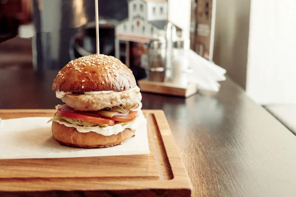 Burger na prkénku jako talíř dřevěný stůl — Stock fotografie