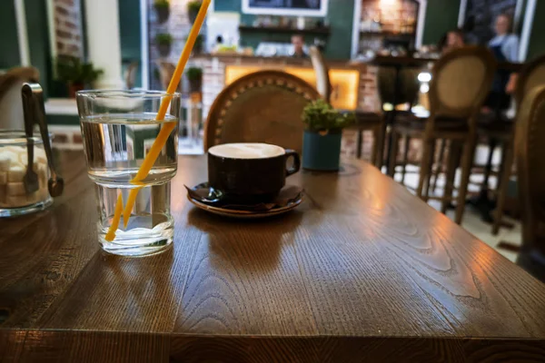 Kaffekopp på bord i Cafe, interiör suddig — Stockfoto