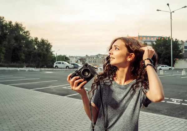 Kvinnan fotograf söker upp med Vintage filmkamera i händerna — Stockfoto