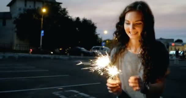 Dospívající dívka Start prskavky v noci ulici před City Lights — Stock video
